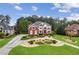 Charming two-story red brick home with beautiful landscaping, lush green lawn, and a curved driveway at 3364 Kylee Dawn Cir, Lawrenceville, GA 30045
