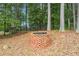 Brick fire pit next to a wooded area with a fence at 3364 Kylee Dawn Cir, Lawrenceville, GA 30045
