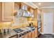 Gourmet kitchen with professional-grade stainless steel appliances, custom cabinetry, and tile backsplash at 3364 Kylee Dawn Cir, Lawrenceville, GA 30045