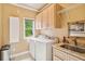 A bright laundry room with a modern washer, dryer, sink, and storage at 3364 Kylee Dawn Cir, Lawrenceville, GA 30045
