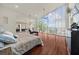 Spacious bedroom with floor-to-ceiling windows, hardwood floors, and views of the surrounding landscape at 4940 Sunrise Ln, Cumming, GA 30041