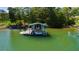 Scenic view of a private boat dock and slip on a tranquil lake, surrounded by lush greenery and clear water at 4940 Sunrise Ln, Cumming, GA 30041