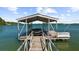 Image shows a boat dock on a lake with a boat inside and a ladder on the right side at 4940 Sunrise Ln, Cumming, GA 30041