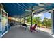 Spacious covered porch with stone wall, ceiling fans, and outdoor seating overlooking lush greenery and a lake view at 4940 Sunrise Ln, Cumming, GA 30041