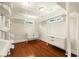 Bright walk-in closet boasts custom shelving, drawers, and hardwood floors for organized storage at 4940 Sunrise Ln, Cumming, GA 30041