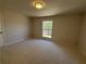 Large bedroom with neutral carpet and paint, and a window with a view at 5685 Kingsport Dr, Sandy Springs, GA 30342