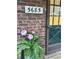 Close-up of house number and green door adorned with pink flowers in front of brick facade at 5685 Kingsport Dr, Sandy Springs, GA 30342