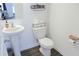 Powder room featuring a pedestal sink and a toilet with storage shelves and modern fixtures at 5790 Thornton Dr, Cumming, GA 30028