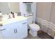 Clean bathroom featuring a white vanity, toilet, and shower with decorative curtain at 5790 Thornton Dr, Cumming, GA 30028