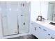 Modern bathroom featuring double sinks, sleek white cabinetry, and glass-enclosed shower at 5790 Thornton Dr, Cumming, GA 30028