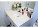 Bathroom with white vanity, modern faucet, and decorative floral arrangement on the counter at 5790 Thornton Dr, Cumming, GA 30028