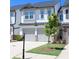 Charming townhome with a two-car garage, a well-manicured lawn, and gray and white accents at 5790 Thornton Dr, Cumming, GA 30028