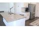 Island kitchen featuring a large granite countertop, stainless steel refrigerator, and ample storage at 5790 Thornton Dr, Cumming, GA 30028