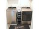 Convenient laundry area with a washer, dryer, storage cart, and decorative floor mat at 5790 Thornton Dr, Cumming, GA 30028