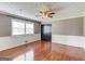 Spacious living room featuring hardwood floors, a ceiling fan, and ample natural light from the large window at 3898 Bay Creek Rd, Loganville, GA 30052