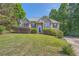Attractive front exterior featuring a stone facade, manicured bushes, and a sloped front lawn at 6790 India Ln, Cumming, GA 30041