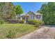Beautiful home exterior featuring a front lawn, mature trees, and charming architectural details at 6790 India Ln, Cumming, GA 30041