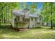 This home features a backyard bordered by lush trees and a deck accessible from the second story at 90 Camden Woods Pl, Dallas, GA 30157