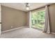 Bright bedroom featuring plush carpet, neutral walls, and natural light streaming through a large window at 90 Camden Woods Pl, Dallas, GA 30157