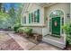 Charming home featuring a green front door with decorative wreath, surrounded by manicured landscaping and green shutters at 90 Camden Woods Pl, Dallas, GA 30157