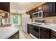 Updated kitchen featuring dark wood cabinets, white countertops, stainless steel appliances and adjacent dining area with access to backyard at 90 Camden Woods Pl, Dallas, GA 30157