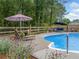 Backyard with a pool, lounge chairs, a blue umbrella, and a well-maintained fence at 1482 Pinebark Ct., Grayson, GA 30017