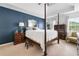 Primary bedroom with a dark blue accent wall and four post bed at 1482 Pinebark Ct., Grayson, GA 30017