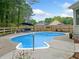 A kidney shaped backyard pool with a concrete surround and a privacy fence at 1482 Pinebark Ct., Grayson, GA 30017