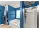 Bright blue bathroom featuring a soaking tub and walk-in shower with sliding glass door at 3235 Avondale Pkwy, Powder Springs, GA 30127