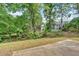 Backyard featuring a concrete patio area surrounded by lush trees and foliage at 5705 Cannonero Dr, Alpharetta, GA 30005