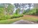 View of the backyard featuring lawn and planting beds with wooded surroundings in a neighborhood setting at 5705 Cannonero Dr, Alpharetta, GA 30005