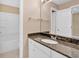 Bathroom featuring a granite countertop, white cabinets, and a mirrored vanity at 5705 Cannonero Dr, Alpharetta, GA 30005