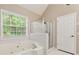 Relaxing bathroom featuring a jetted tub and a separate glass enclosed shower at 5705 Cannonero Dr, Alpharetta, GA 30005