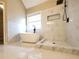 Bright bathroom featuring a soaking tub, walk-in shower with black fixtures, and bright tile floors at 5705 Cannonero Dr, Alpharetta, GA 30005