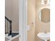 Powder room featuring a pedestal sink and decorative mirror with staircase in background at 5705 Cannonero Dr, Alpharetta, GA 30005