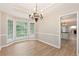Bright dining room area with wood floors, a chandelier, and large windows at 5705 Cannonero Dr, Alpharetta, GA 30005