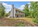 Side rear exterior view of the home with a chimney and a grass backyard at 5705 Cannonero Dr, Alpharetta, GA 30005