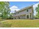 Back exterior of home showcasing a large yard with mature trees at 5705 Cannonero Dr, Alpharetta, GA 30005