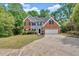 Beautiful home featuring a brick and siding exterior, two-car garage, and lush lawn with landscaping at 5705 Cannonero Dr, Alpharetta, GA 30005