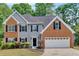 Charming home boasts a brick and siding facade, attached garage, and well-manicured landscaping at 5705 Cannonero Dr, Alpharetta, GA 30005