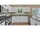 Updated kitchen featuring white cabinets, stainless steel appliances, and hardwood flooring at 5705 Cannonero Dr, Alpharetta, GA 30005