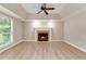 Bright living room featuring a fireplace, fan, and large window at 5705 Cannonero Dr, Alpharetta, GA 30005