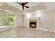 Bright living room featuring a fireplace, fan, and large window at 5705 Cannonero Dr, Alpharetta, GA 30005