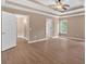 A spacious main bedroom with a tray ceiling, ceiling fan, ensuite bath, and hardwood floors at 5705 Cannonero Dr, Alpharetta, GA 30005