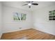 Bright bedroom with wood floors, ceiling fan, and natural light from two large windows at 1780 Kinridge Rd, Marietta, GA 30062