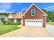 Charming home featuring a well-manicured lawn, brick accents, and a two-car garage at 2620 Matlin Way, Buford, GA 30519