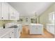 Kitchen features a center island, white cabinets, hardwood floors and stainless appliances at 2620 Matlin Way, Buford, GA 30519