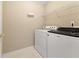 Laundry room features a washer and dryer with overhead shelving, streamlining household tasks at 2620 Matlin Way, Buford, GA 30519