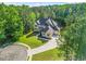 Aerial view of a distinguished home with manicured lawns, an extended driveway, and mature trees at 3298 Alcovy Club Ct, Dacula, GA 30019