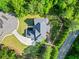 Overhead view of an upscale home surrounded by mature trees, a long driveway, and manicured lawns at 3298 Alcovy Club Ct, Dacula, GA 30019